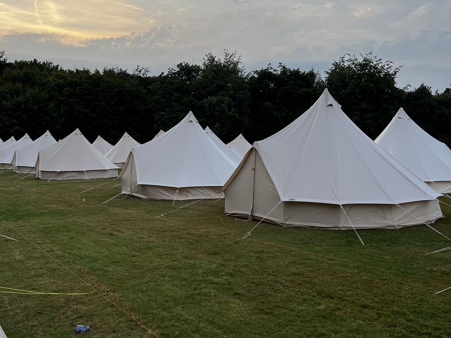 Festival bell tent village under an evening sky
