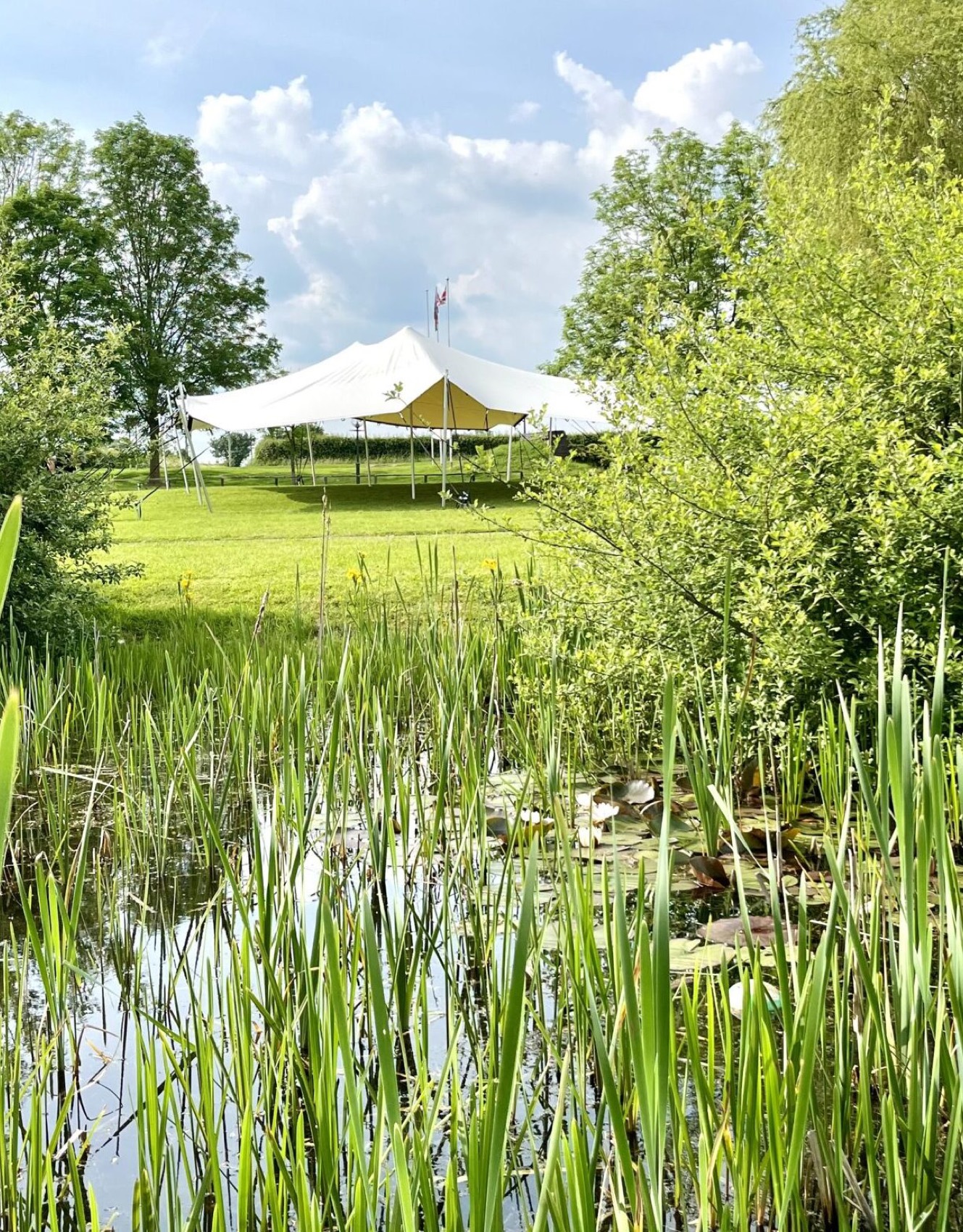 Small stretch tent pitched beside a pond