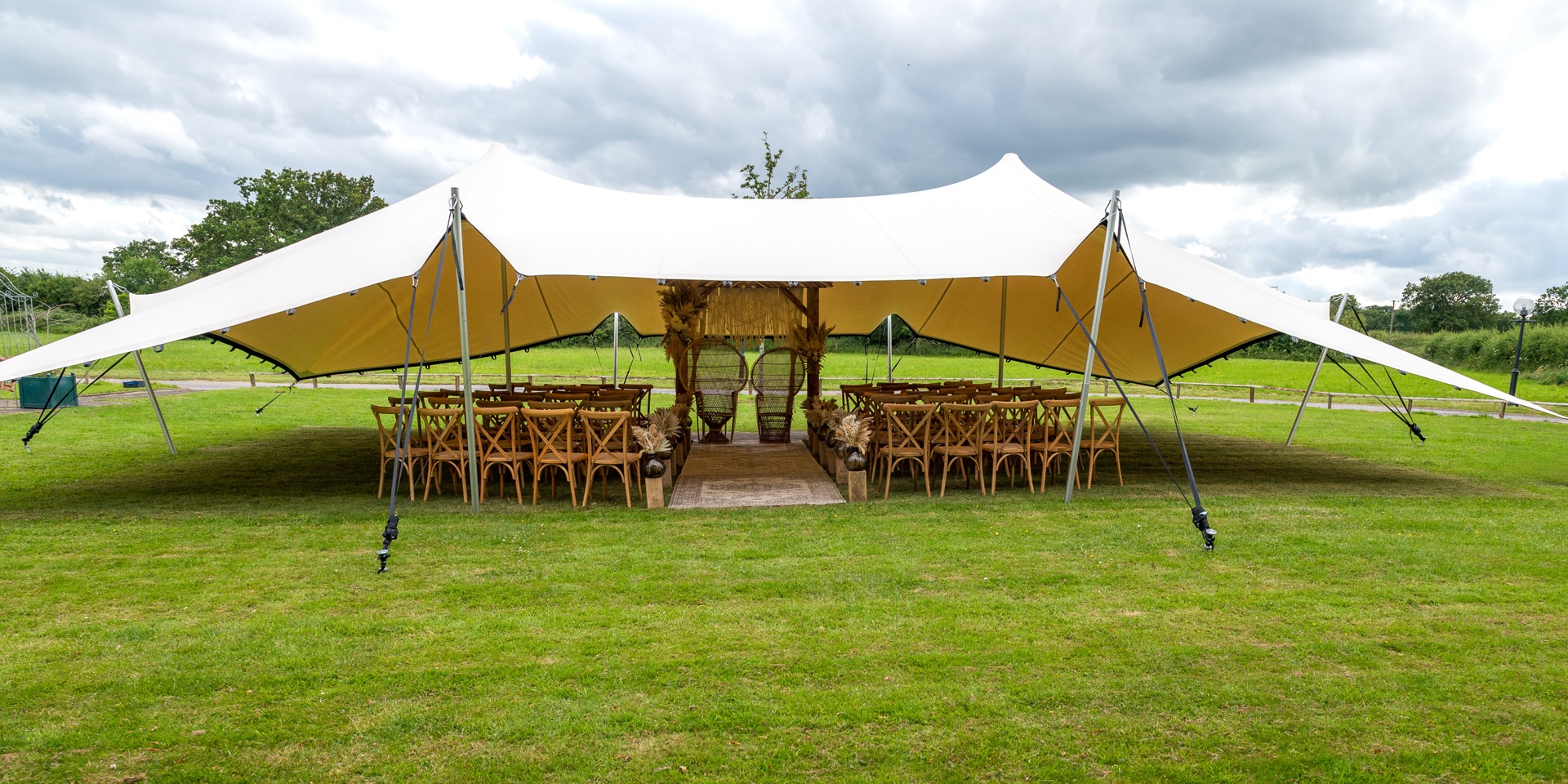 Stretch tent front-on with open sides, dressed for a wedding