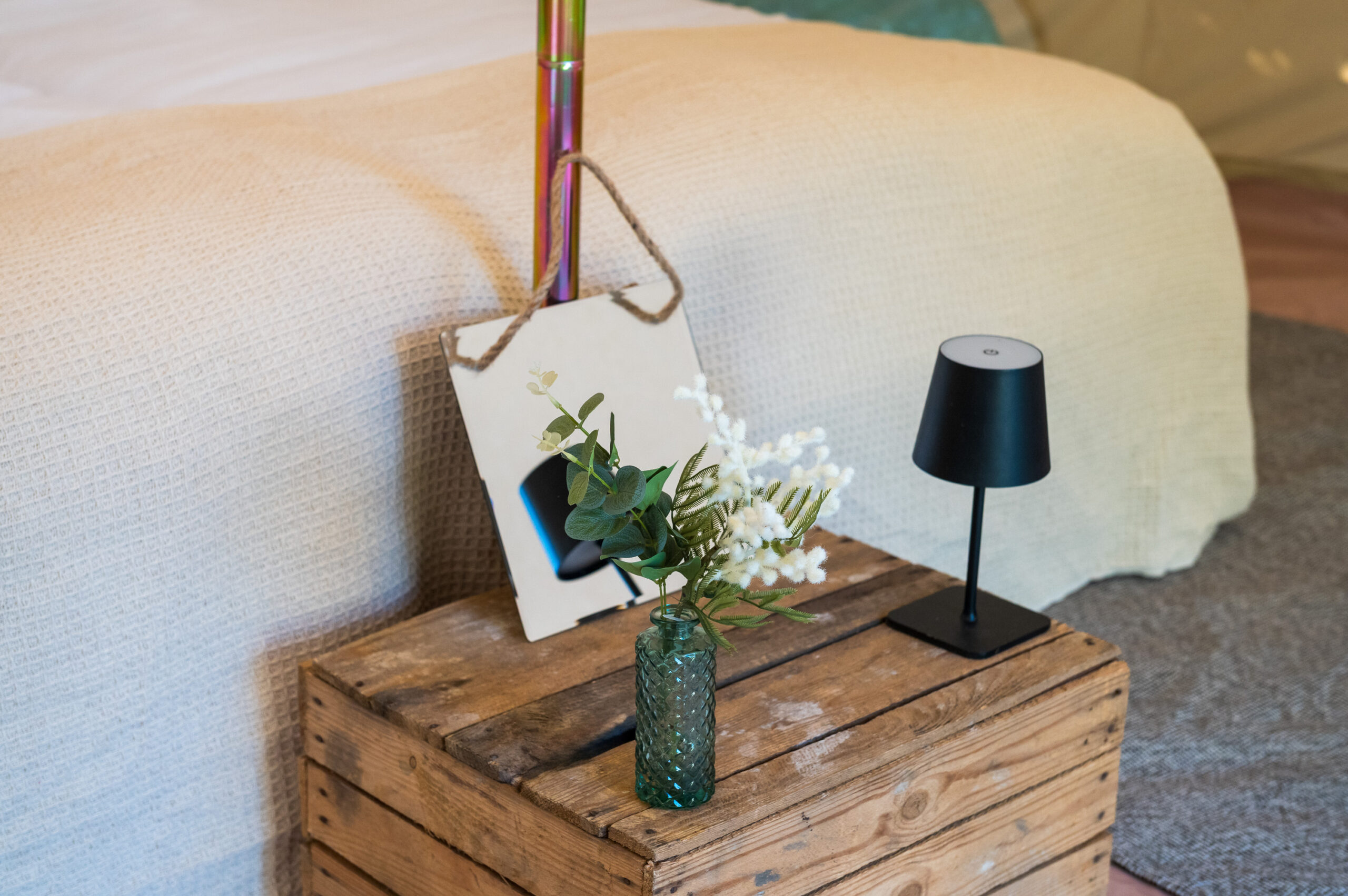 Luxury bell tent interior styled with rugs, cushions and faux flowers