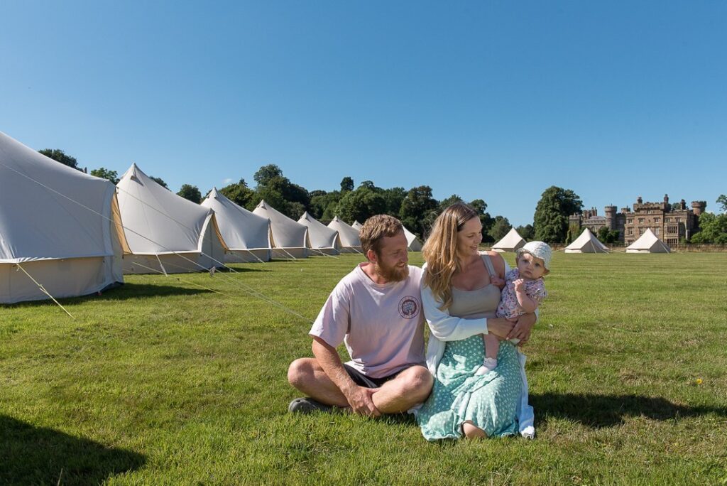 Photo of a family in fornt of a glamping tent village in York
